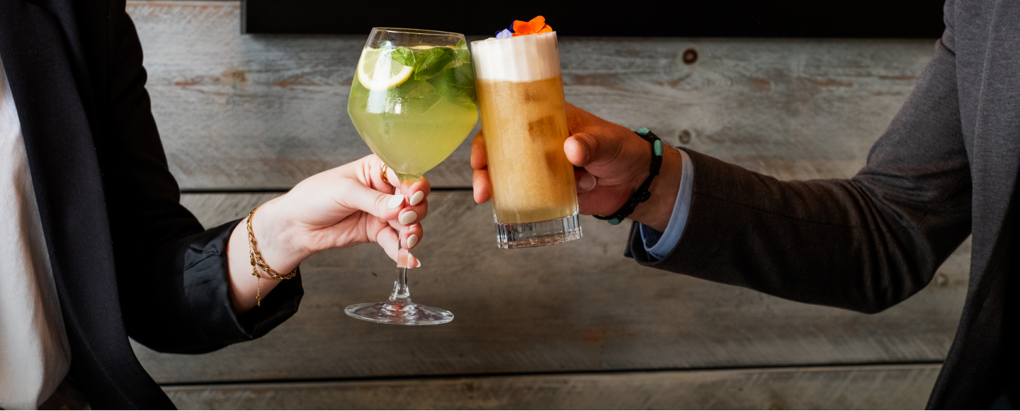 Two people saying cheers with cocktails